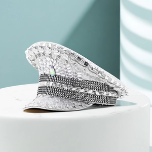 Close-up of a silver sequined military hat with iridescent gemstone and rhinestone trim