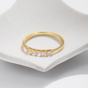 Elegant gold S925 sterling silver ring featuring five iridescent round moonstones on white stand