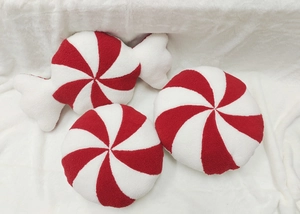 Detailed view of plush red and white peppermint candy pillows for Christmas decor