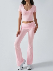 Détail d'un ensemble rose pour femme avec haut à col en V et pantalon évasé taille haute