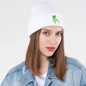 Stylish white knitted beanie with green frog embroidery worn with a light blue denim jacket