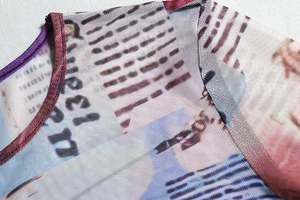 Macro detail of round neck stitching and abstract print on sheer mesh long sleeve crop top
