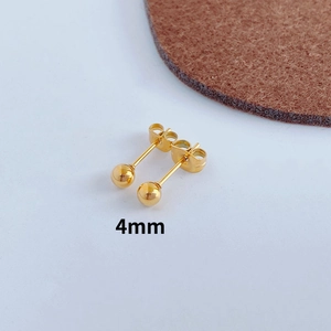 Detailed view of 4mm golden sphere stud earrings with butterfly backs on white card