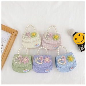 Detail of five pastel kid handbags with pearl handles and floral heart patterns