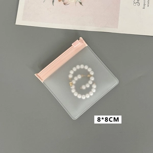 Detailaufnahme der rosa transparenten 8x8cm Schmucktasche mit Perlenohrringen innen