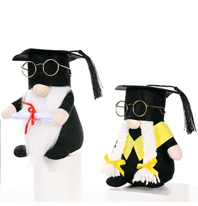 Close-up of graduation gnomes with black mortarboards, golden glasses and diploma scrolls