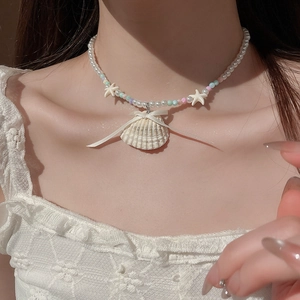 Close-up of shell and starfish beaded necklace with a silk bow on a woman's neck