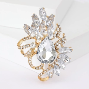 Macro shot of gold brooch with pear-cut crystal and marquis rhinestones on geometric base