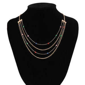 Detail of four-layered gold-tone chain necklace with colorful enamel beads on a neck bust