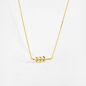 Detailed macro view of the golden leaf pendant and delicate sterling silver chain link