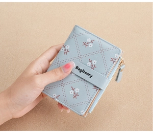 Detail of light blue PU leather wallet with floral diamond pattern and metal logo