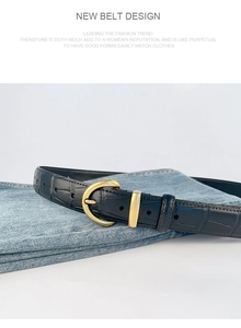 Detailed close-up of a black crocodile-pattern leather belt with a vintage gold semi-round buckle