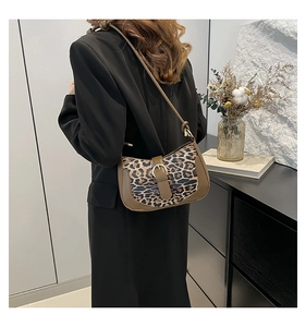 Close-up of leopard print shoulder bag worn by model in a minimalist interior setting
