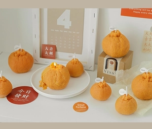 Detailed realistic orange shaped scented candles with citrus texture and kraft gift box