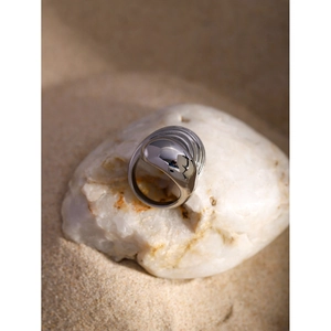 Macro detail of silver layered teardrop ring with polished finish on white stone