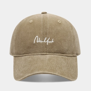 Détail de la casquette de baseball kaki avec broderie New York blanche et texture en coton