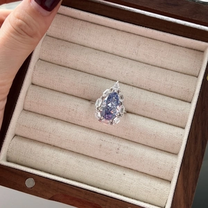 Macro shot of S925 silver ring featuring a pear-cut purple gemstone in luxury jewelry box