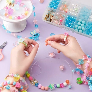 DIY jewelry making kit with green beads, accessories and scissors in a clear box