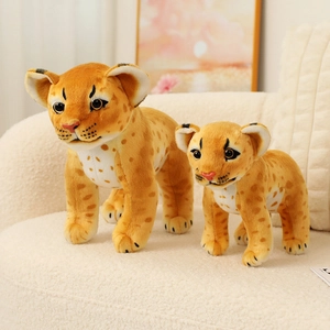 Realistic leopard cub plush toy set with two sizes on a soft white sofa in a cozy home setting