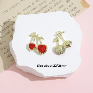 Detail of cherry alloy charms with red heart crystals and textured metal back