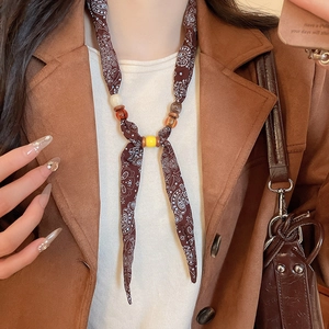 Detail of paisley pattern silk scarf necklace with vintage beads and brown fabric