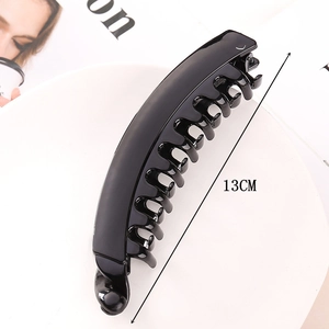 Detail shot of a 13CM black minimalist hair claw clip on a white tray with sleek finish