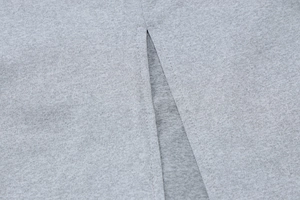 Détail macro du tissu en maille grise de qualité montrant les coutures et la fente latérale