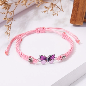 Detail of pink woven bracelet featuring a purple butterfly and sparkling rhinestones