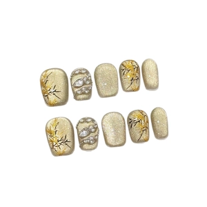 Champagne glitter press-on nails with black bamboo painting and rhinestones