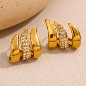 Macro shot of gold-plated triple claw earrings with pavé set sparkling crystal zircons