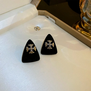 Detailed close-up of a black flocked triangle earring featuring a silver cross emblem