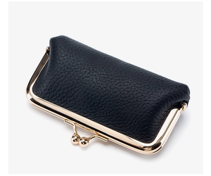 Close-up of black leather coin purse with golden metal frame and dual bead clasp