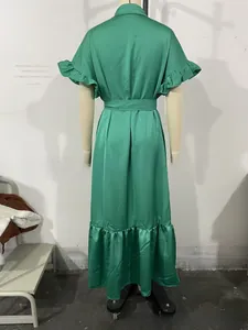 Détail de la robe en satin vert avec manches volantées élégantes et taille nouée