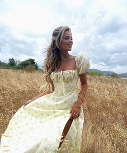 Detail of a floral puff sleeve maxi dress with side slit in a golden wheat field