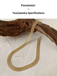 Detailed view of vintage gold woven mesh titanium necklace on a natural wood branch