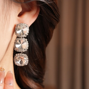Close-up of triple-row round diamond tassel earrings with sparkling clear zircon stones