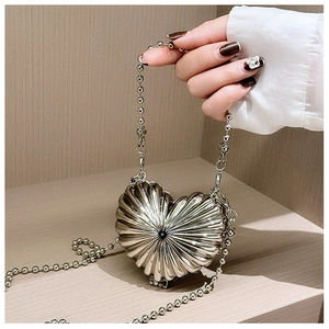 Detail of silver heart-shaped metal shell bag with radiant ridges and bead chain