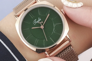 Close-up of a ladies quartz watch featuring a green dial and rose gold mesh strap