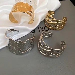 Irregular textured metal open bangles in gold and silver leaf pattern design