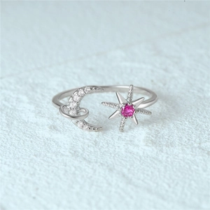 Macro detail of S925 silver open ring featuring a sparkling moon and pink gemstone star