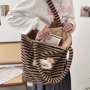 Detail of plush striped tote bag with cute cartoon dog patch in a cozy home setting