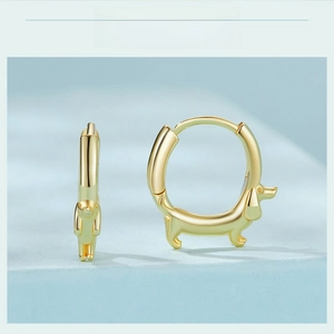Detail view of 18K gold plated S925 silver dachshund hoop earrings on blue surface