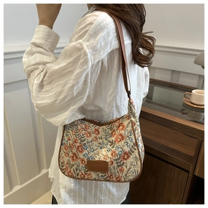 Detail of vintage floral linen tote bag with brown leather trim and textile strap
