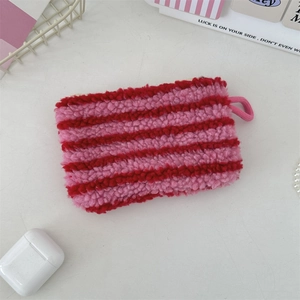 Macro view of plush striped pouch made of soft faux shearling with a zipper and hanging loop