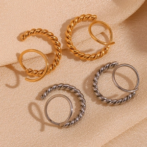 Detailed view of twisted rope hoop earrings in polished gold and silver metallic finishes