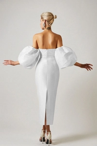 Detailed back view of a white off-shoulder midi dress featuring dramatic puff sleeves