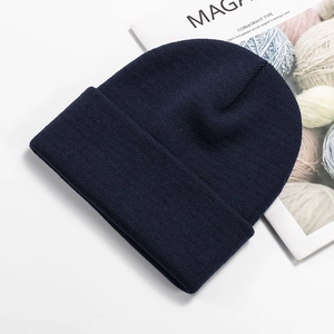 Detailed close-up of navy blue knit beanie with fine stitching and thick texture