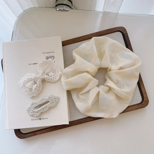 3-piece hair accessories set with floral scrunchie and lace bow clips on vintage book