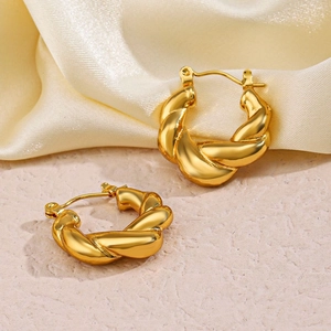 Boucles d'oreilles créoles torsadées en or acier inoxydable sur fond de soie dorée
