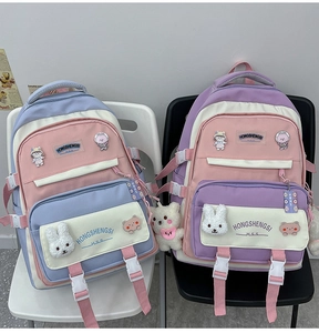 Detail of multi-pocket backpacks in pastel colors featuring plush charms and badges